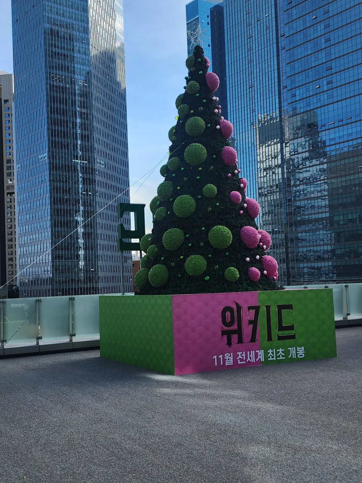 용산 아이파크몰 〈위키드〉 홍보 트리 — 그린 볼 면과 받침 문구
